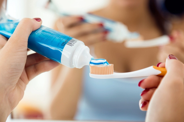 Mujer con cepillo y crema de dientes