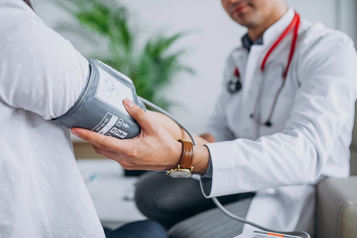 Joven médico midiendo la presión